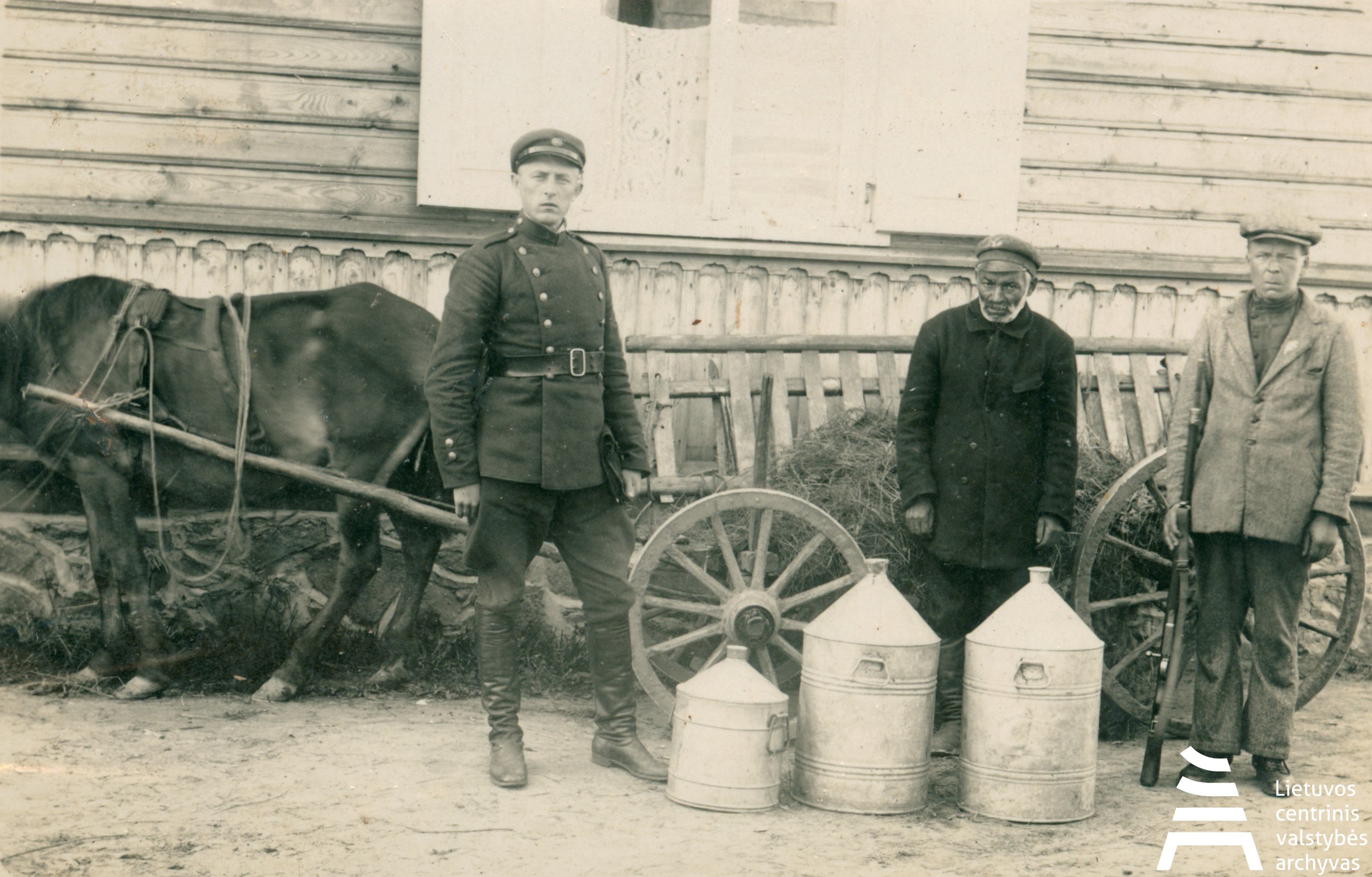 Lithuanian Central State Archives, A police officer next to the arested smuggling of alcohol. [1918-1940]. P-12190.